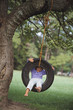 Young girl sitting in tire swing
