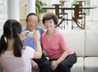 Asian girl taking photograph of grandparents