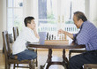 Asian grandfather and grandson playing chess