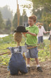 Young boy putting hat on scarecrow