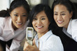 Asian businesswomen taking own photograph with cell phone