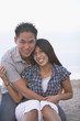 Asian couple hugging and smiling at beach