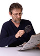 elderly man reads a newspaper