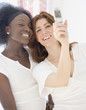 Two women taking photograph with cell phone