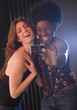 Two women taking photograph in nightclub