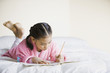 Pacific Islander girl writing in notebook