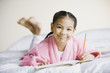 Pacific Islander girl writing in notebook