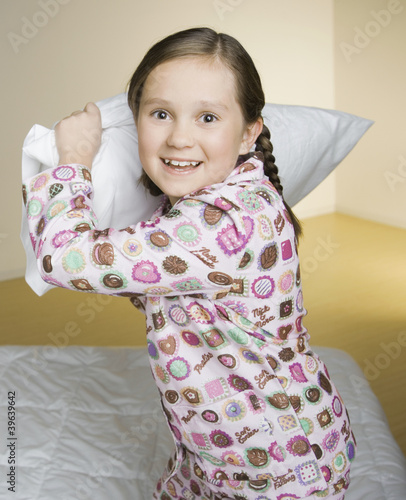 Photo: Portrait of girl having pillow fight Portrait of girl having pillow fight