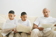 Indian father and sons reading newspaper