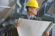 Businessman in hard hat holding blueprints