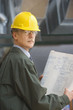 Businessman in hard hat holding blueprints