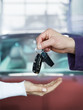 Key delivery between customer and mechanic in front of new car