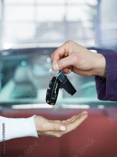 Photo: Key delivery between customer and mechanic in front of new car Key delivery between customer and mechanic in front of new car