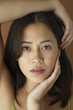Asian woman with hand on face