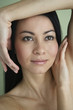 Asian woman with hands framing face