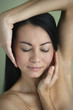 Asian woman with hands framing face