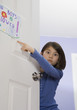 Asian girl pointing at sign on bedroom door