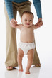 Russian mother helping baby walk