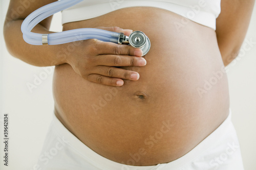 Photo: Pregnant African woman holding stethoscope on belly Pregnant African woman holding stethoscope on belly