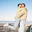 Hispanic couple hugging at beach