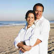 Hispanic couple hugging at beach