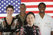 Multi-ethnic people standing in front of American flag