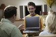 Hispanic boy showing laptop to parents