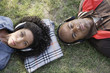 African couple listening to headphones in grass