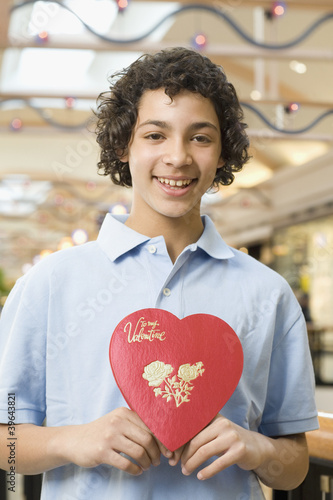 Photo: Multi-ethnic teenage boy holding Valentine's Day heart Multi-ethnic teenage boy holding Valentine's Day heart