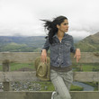 Hispanic woman leaning on fence