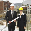 Businesspeople wearing hard hats at construction site