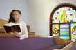 African American woman reading Bible in church