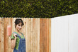Hispanic woman painting fence