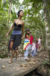 Hispanic woman and children exploring woods