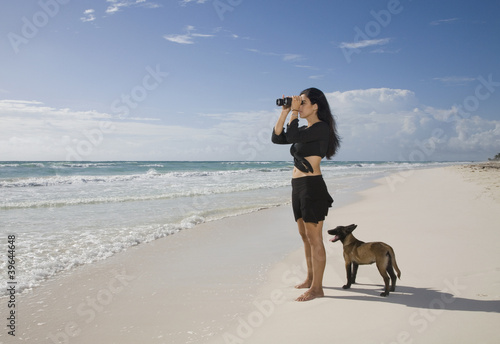 Photo: Hispanic woman using binoculars at beach Hispanic woman using binoculars at beach