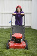Mixed Race boy pushing lawn mower