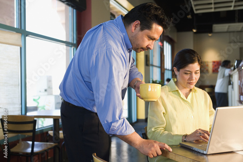 Photo: Multi-ethnic businesspeople working at cafe Multi-ethnic businesspeople working at cafe