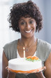 African American woman holding birthday cake