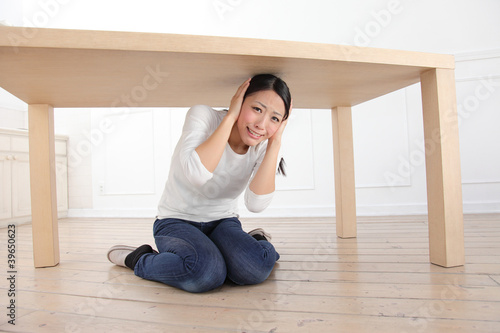 Photo: 机の下に隠れる女性 机の下に隠れる女性