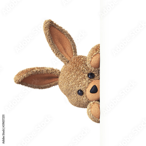 Illustration: Stuffed bunny peeking behind blank board - upright Stuffed bunny peeking behind blank board - upright