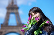 Portrait of cheerful young lady in Paris with bunch of fresh spr
