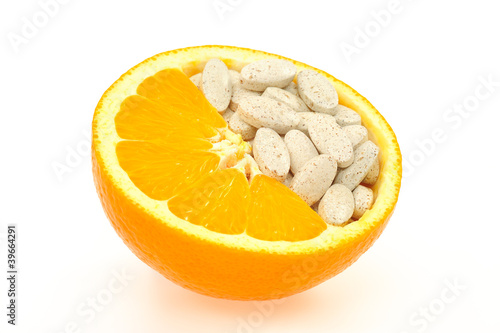 Photo: Close up of orange and pills isolated - vitamin concept Close up of orange and pills isolated - vitamin concept