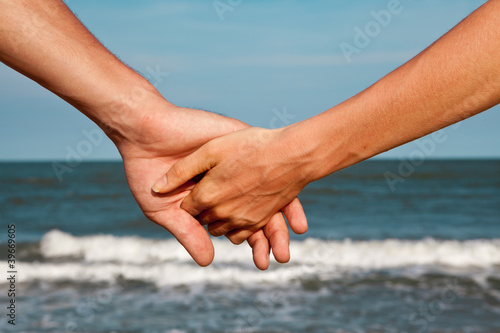 Photo: Couple of hands on the sea view Couple of hands on the sea view