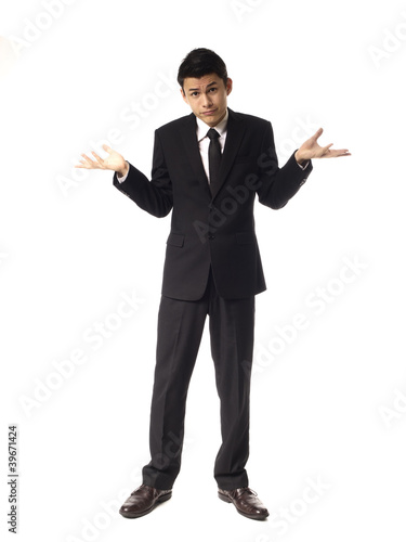 Photo: Young Asian Man shrugging Over White Background. Young Asian Man shrugging Over White Background.