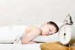 Boy 4 years sleeping bed old alarm clock brick wall