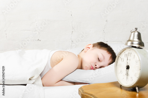 Photo: Boy 4 years sleeping bed old alarm clock brick wall Boy 4 years sleeping bed old alarm clock brick wall