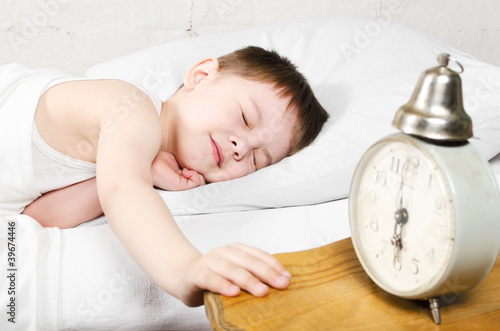 Photo: Boy 4 years sleeping bed old alarm clock brick wall Boy 4 years sleeping bed old alarm clock brick wall
