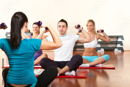 Photo: Fitness group of people with lifting dumbbell Fitness group of people with lifting dumbbell