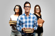 young students holding books over grey background