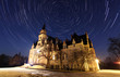 Night sky with stars trail and ancient castle in Slovakia